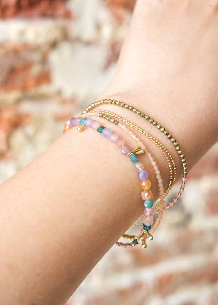 boho armbandje met verschillende snoertjes in roze en lila kleuren